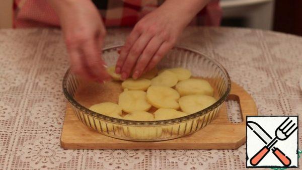 The bottom of the heat-resistant form in which we will cook the casserole, lubricate with vegetable oil.
The first layer is spread with potato slices.
Season with salt and pepper.
