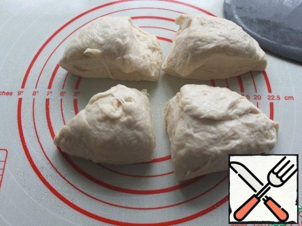 Knead the dough on the work surface. No additional flour is required.
Divide the dough into four parts.