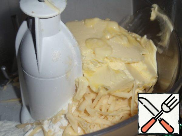 I put all the ingredients in the bowl of a blender with a hook attachment and knead the dough. Then I put it on the table and knead it until a smooth, soft mass.
If you knead by hand, then sift the flour on the table, add paprika, salt, sugar and baking powder. Mix well.
Grate the cheese and add the butter to the flour. Knead well.