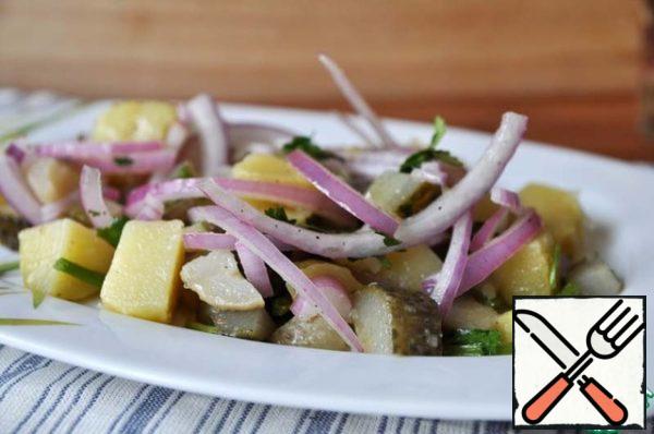 On a serving plate, spread the potatoes with gherkins and onions.