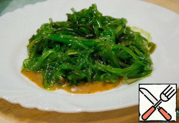 Pour a little sesame sauce on a plate, put the chuka seaweed salad on it.