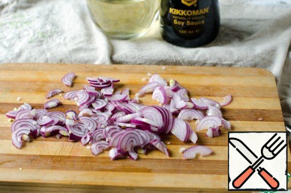 Peel the red onion and cut it into half rings.