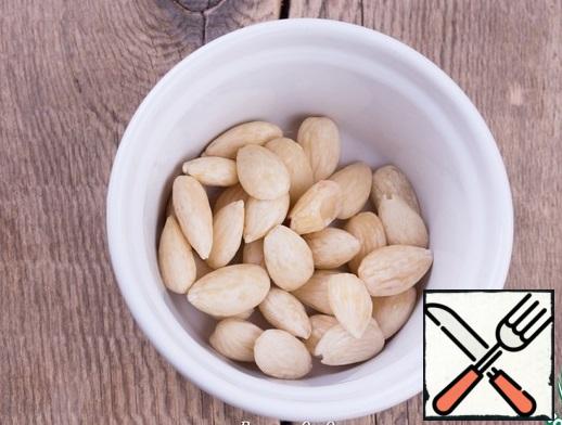Soak the almonds in boiling water for 10 minutes. Peel the almonds from the brown skin.