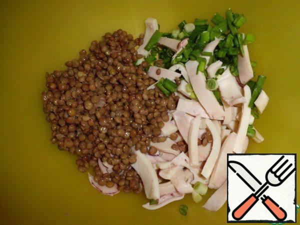 Lentils are washed and boiled for 20-25 minutes.
In parallel, we boil the mushrooms. We boil the squid in any convenient way. Cool and cut into strips. Add the chopped green onions and lentils.