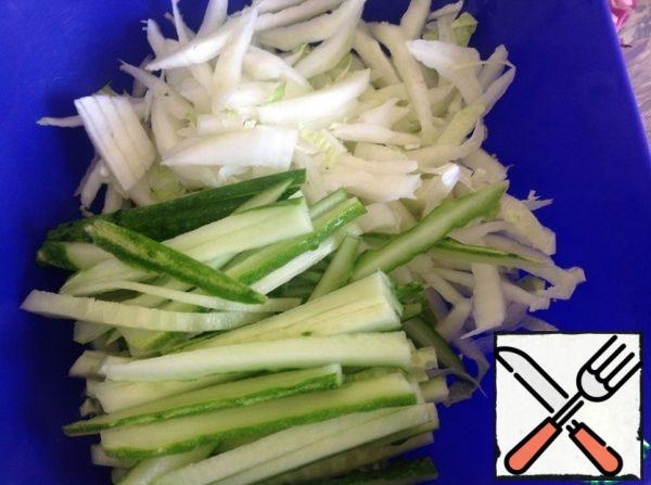 Chop the cabbage, cut the cucumber into strips.