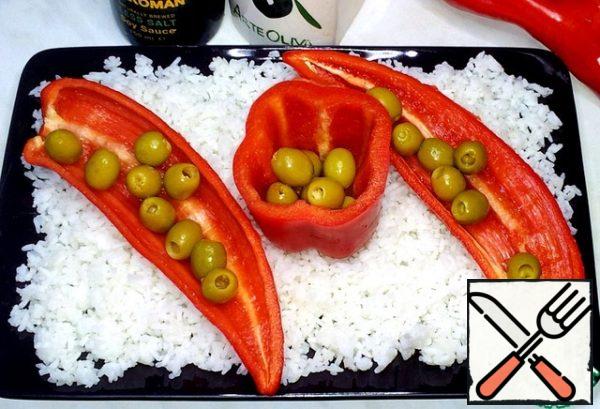 I put three halves of pepper on the rice, and olives in the pepper.