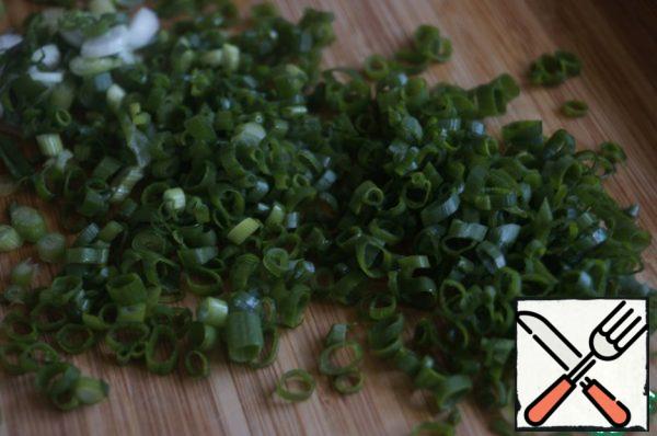 Finely chop the green onion. Sesame seeds are fried in a frying pan. Mix all the ingredients for the salad in a bowl.