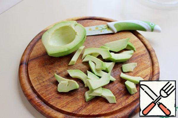 Peel the avocado and cut it into thin slices.