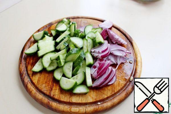 Cut the cucumber into small pieces. Salad red onion-feathers.