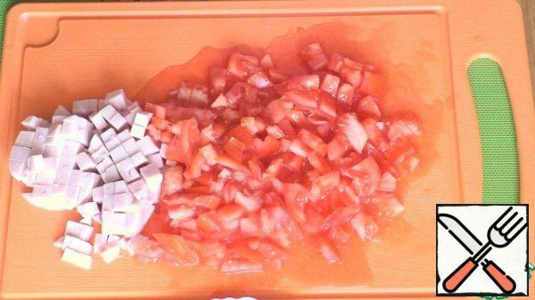 Cut the tomatoes and ham into small cubes and transfer them to a salad bowl. If you do not like excess liquid in salads, then drain the juice from the tomatoes.