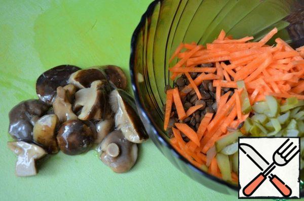 Slice the pickled cucumber and mushrooms.
Add to the lentils.