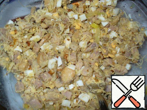 Boil the eggs hard-boiled. Cut them into cubes. In a salad bowl, mix the cubes of pork, fried mushrooms with onions, eggs, grated cheese and chopped walnuts.