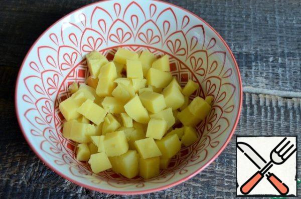 Boil the potatoes in salted water, cool and cut into medium cubes.