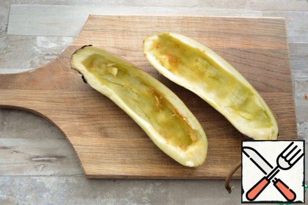 Calculation of products per eggplant.Cut the eggplant lengthwise, scrape the pulp with a teaspoon, leaving the walls 1 cm.