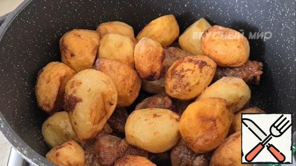 Add salt to the fried potatoes and shanks, add about 100 ml of oil and simmer over low heat under the lid for 20 minutes.