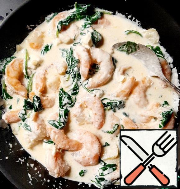 Once the spinach is browned, add the shrimp. If raw, then cook them until pink, and if ready-warm up for a minute.
Put the spaghetti on a plate and pour the sauce over it.