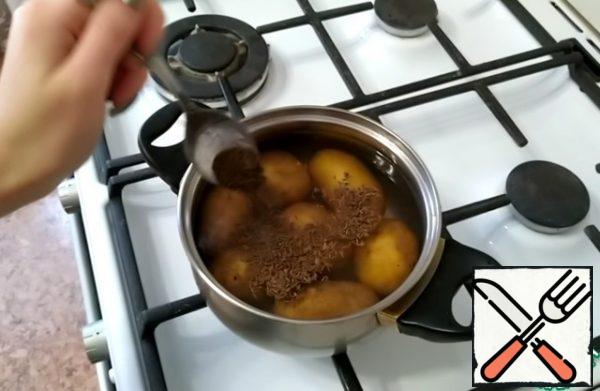 Medium-sized potatoes should be washed and put in a saucepan.
Add water, salt and cumin.