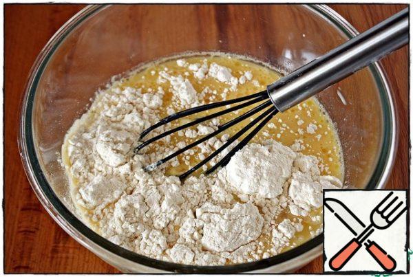 After that, add the milk, vegetable oil, and mix. Then pour out the flour, baking powder and mix well again.