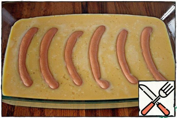 The baking dish is lightly greased with vegetable oil, pour the egg mixture into the mold, add the sausages and put in the oven, preheated to 180 degrees for about 25 minutes.
