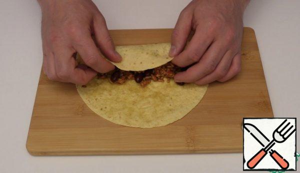 Next we put the tortilla spread our filling on it and twist it into a tube