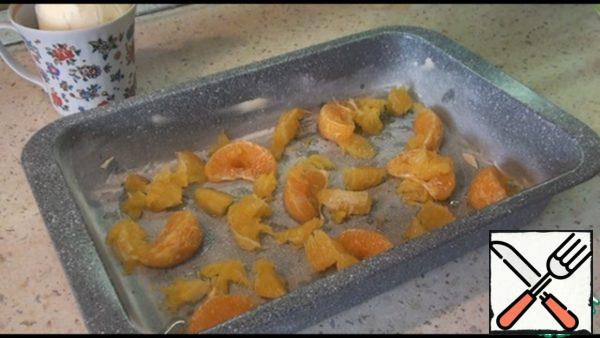 At the bottom of the mold, we spread peeled oranges or tangerines.