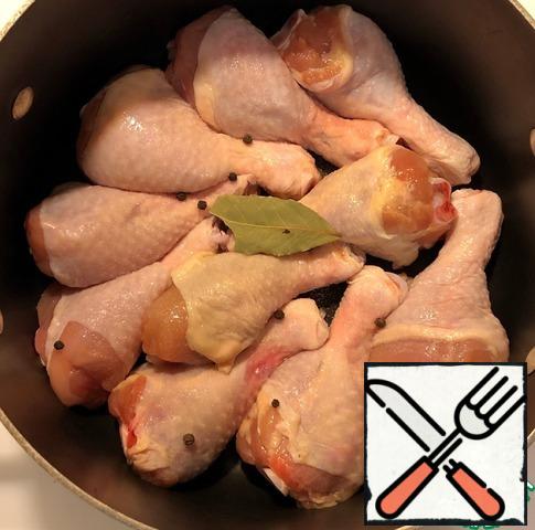 Spread the chicken legs in 1 layer in a 5-liter saucepan. Pour 1.5 cups of water. After boiling, remove the foam. Add 1 bay leaf and black pepper to taste.
Note: The chicken pieces may not be partially covered with water, which is normal, as the carrots and onions will partially occupy the space between the chicken shins and the water level will rise. The juice from apples and meat will also stand out.