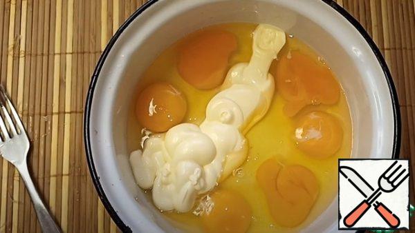 In a bowl, beat the chicken eggs, and add the mayonnaise, whisk.