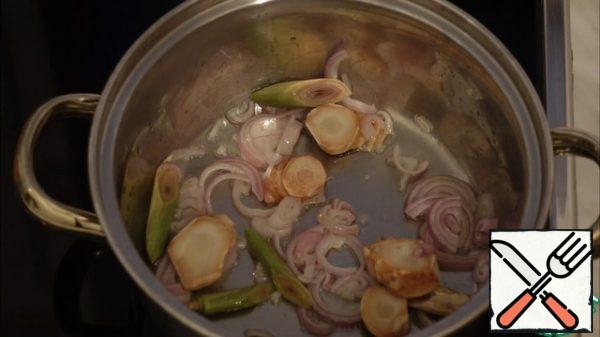 Lightly fry in vegetable oil, onion, galangal and lemongrass.
