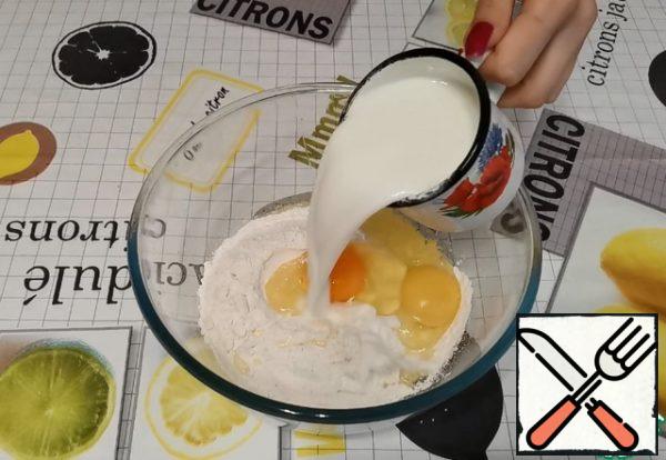 Prepare the dough for the pancakes.
In a bowl, pour the flour. Add salt. Break the eggs. Gradually add 2 cups of milk. Maybe a little more.