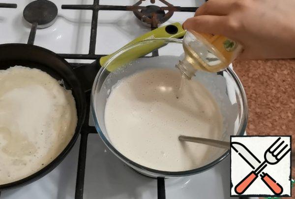 While the first pancake is being fried, add vegetable oil to the dough. Mix well.
At the same time, the pan is no longer greased with oil.