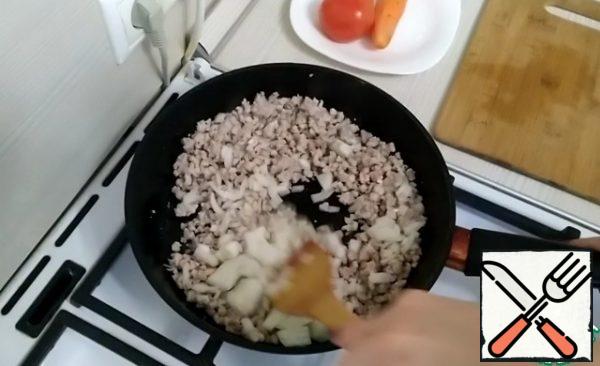 Meanwhile, finely chop the onion.
Pour the onion into the minced meat. Fry a little more.