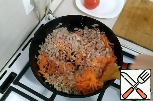 Meanwhile, grate the carrots on a coarse grater.
Pour the carrots into the pan. Fry it.