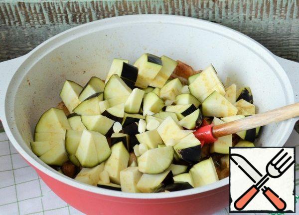 Add eggplant cubes and garlic slices. Fry for a couple of minutes over medium heat.