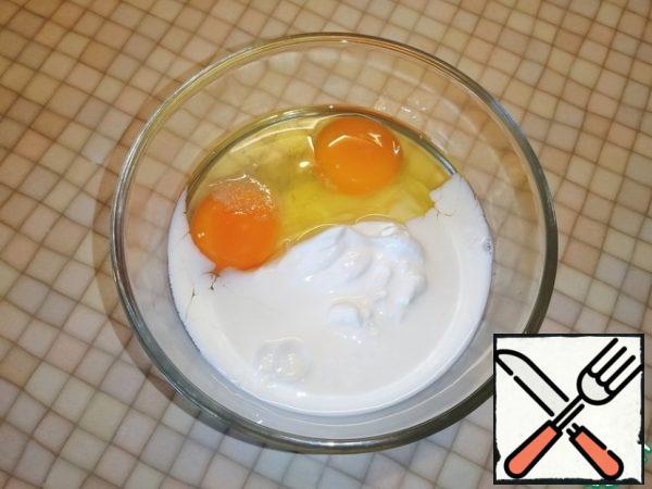 In a small bowl, beat two eggs with milk and sour cream.