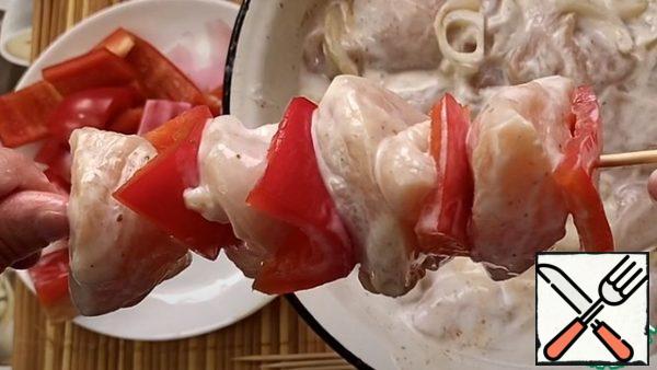 After half an hour, take a skewer and prick the chicken pieces and bell pepper.
