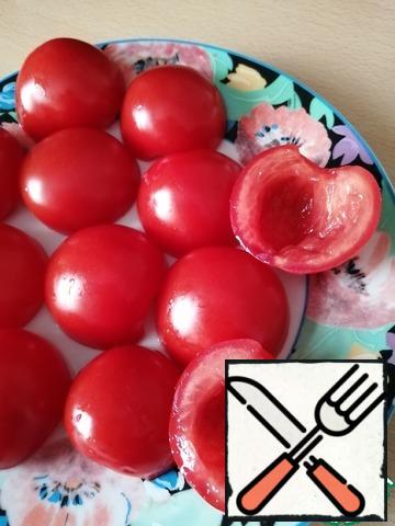 So, wash the tomatoes, wipe them dry.
Cut in half and spoon out the middle with the seeds.
Then fold the cut down to make more juice glass.