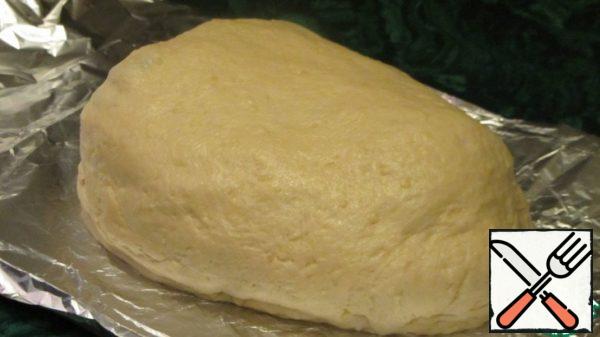 Form a ball from the dough, put it on a greased foil and shape it into a circle or oval with your hands. Wrap the marinated meat in the dough.