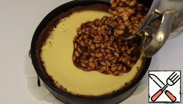 Caramel peanuts spread on top of the cheesecake form