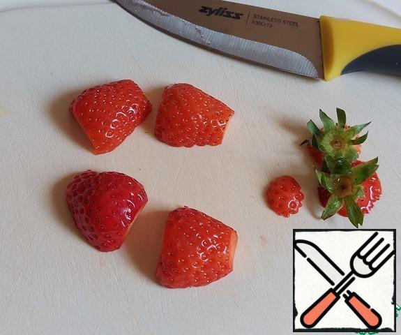 With strawberries, first cut the sepals and only then rinse with water, as between the fruit and the "green" can come across sand, dust, soil or something else that is not washed out immediately.
Cut in half lengthwise.