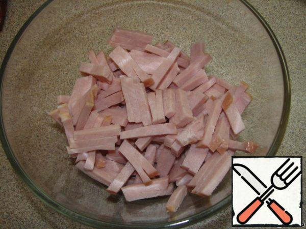 Cut the ham into strips and put it in a salad bowl.