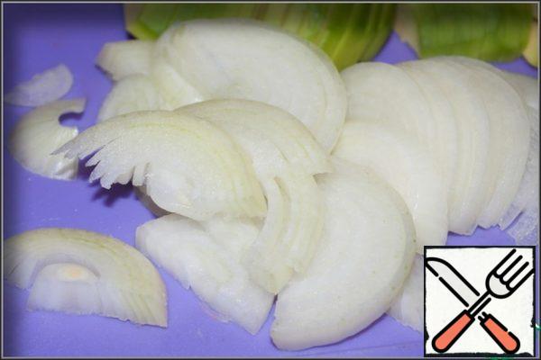 Peel and slice the onion into thin half-rings.