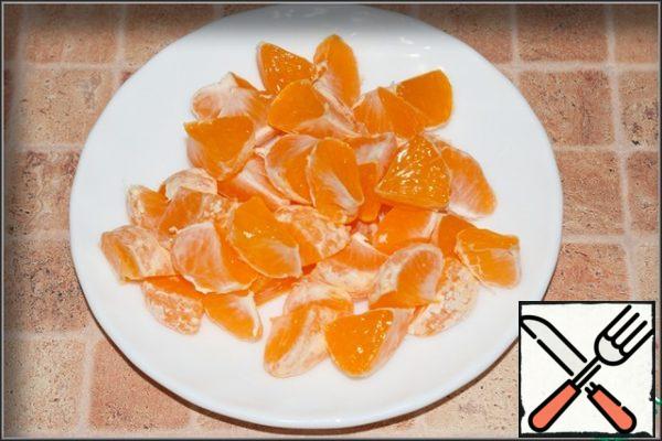 Peel the tangerines and divide them into slices. Cut each slice in half, removing the seeds, if any.