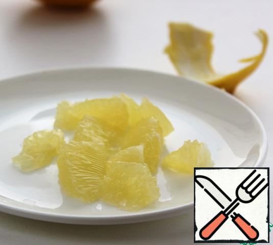 With a sharp knife, cut off the lemon peel along with the white pulp, cut the pulp into slices between the films, and coarsely chop.
