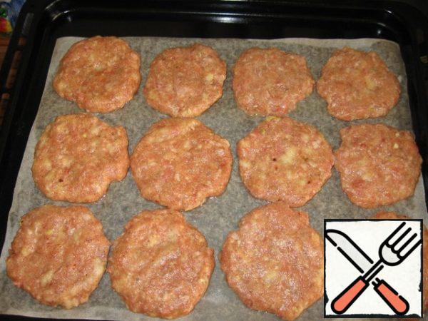 To the minced meat, add salt, pepper, seasonings to the meat, finely chopped garlic and dill, soaked in milk or water and twisted in a meat grinder loaf, 2 eggs, knead
well and form tortillas (I have 12 pieces).
Place them on a greased baking sheet.