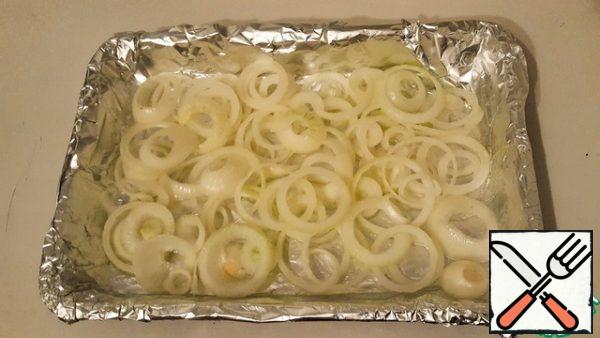 Cover the mold with foil, grease it with plenty of sunflower oil, cut the onion into rings, and put it in the mold, add a little salt and pepper.