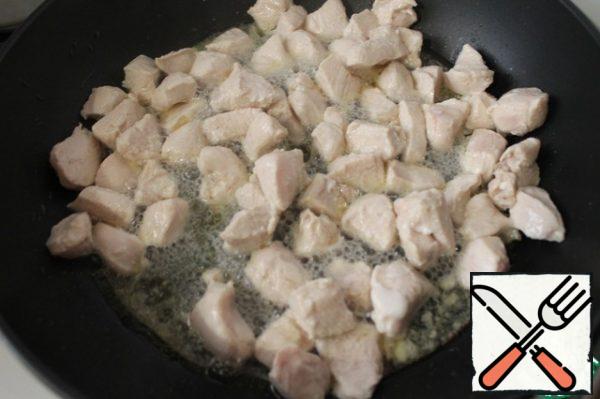 Cut the chicken fillet into small pieces and put it out in oil from dried tomatoes or olive oil. You can also fry it. Let's add a little salt.