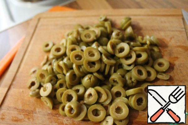 We drain the brine from the olives, cut them into rings.