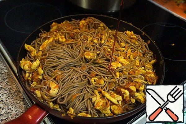 Add turmeric, salt, pepper, and mix. Fry until the chicken is ready-5 minutes. Send the finished buckwheat noodles to the pan. Pour in the teriyaki sauce and stir.