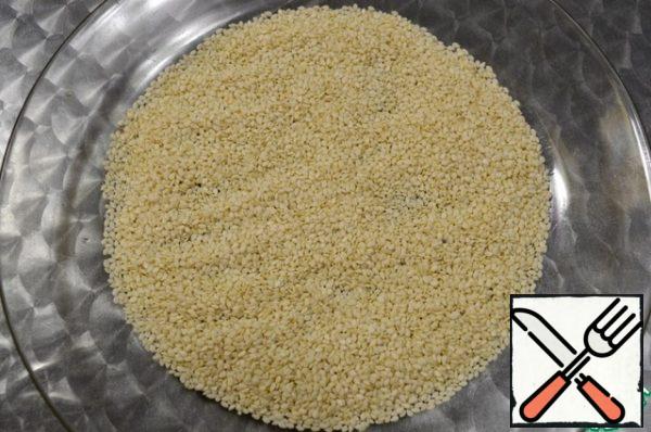 Pour the white sesame seeds on a large flat plate.