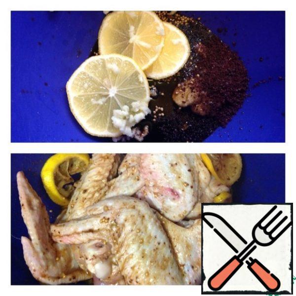 Spread the lemon slices, sumac and garlic passed through the press. We mix the marinade and spread our wings. Carefully smear the marinade, slightly "cheating" with your hands. We leave the chicken for at least an hour for marinating.